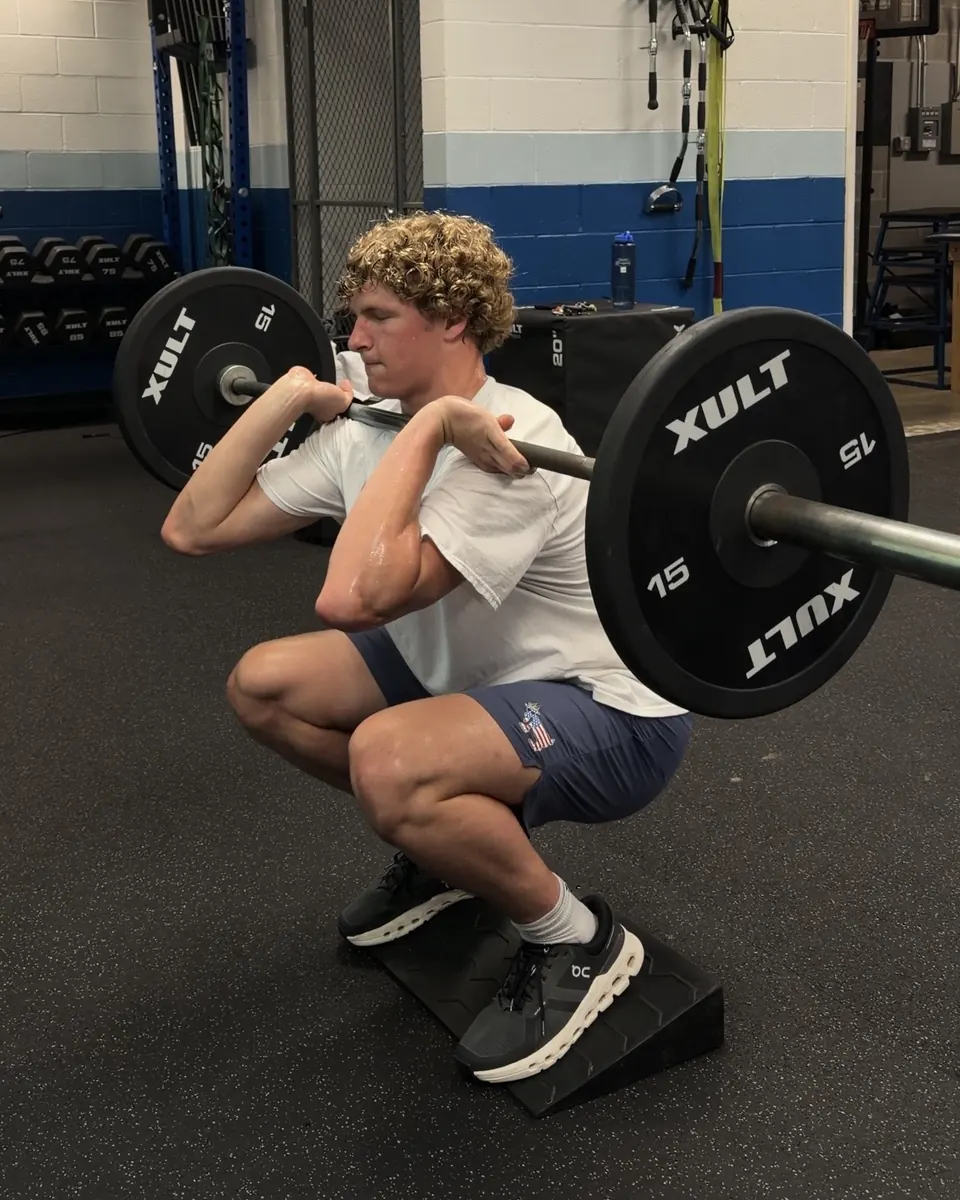 Athlete front squatting a barbell on a slant board