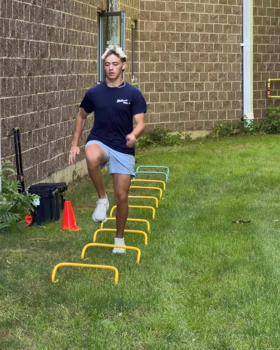 Athlete sprinting through wickets during summer performance training